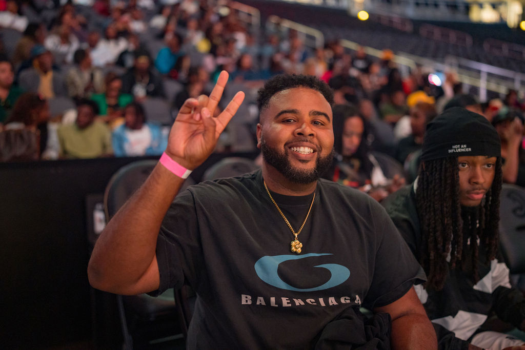 Smiling attendee throwing a peace sign